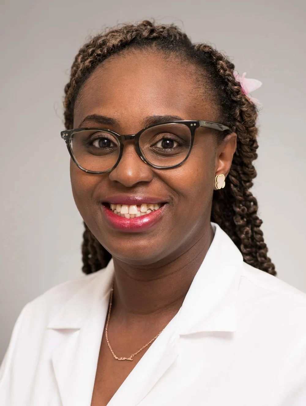 Dr. Ifeoluwa Malmberg, smiling, in a white coat