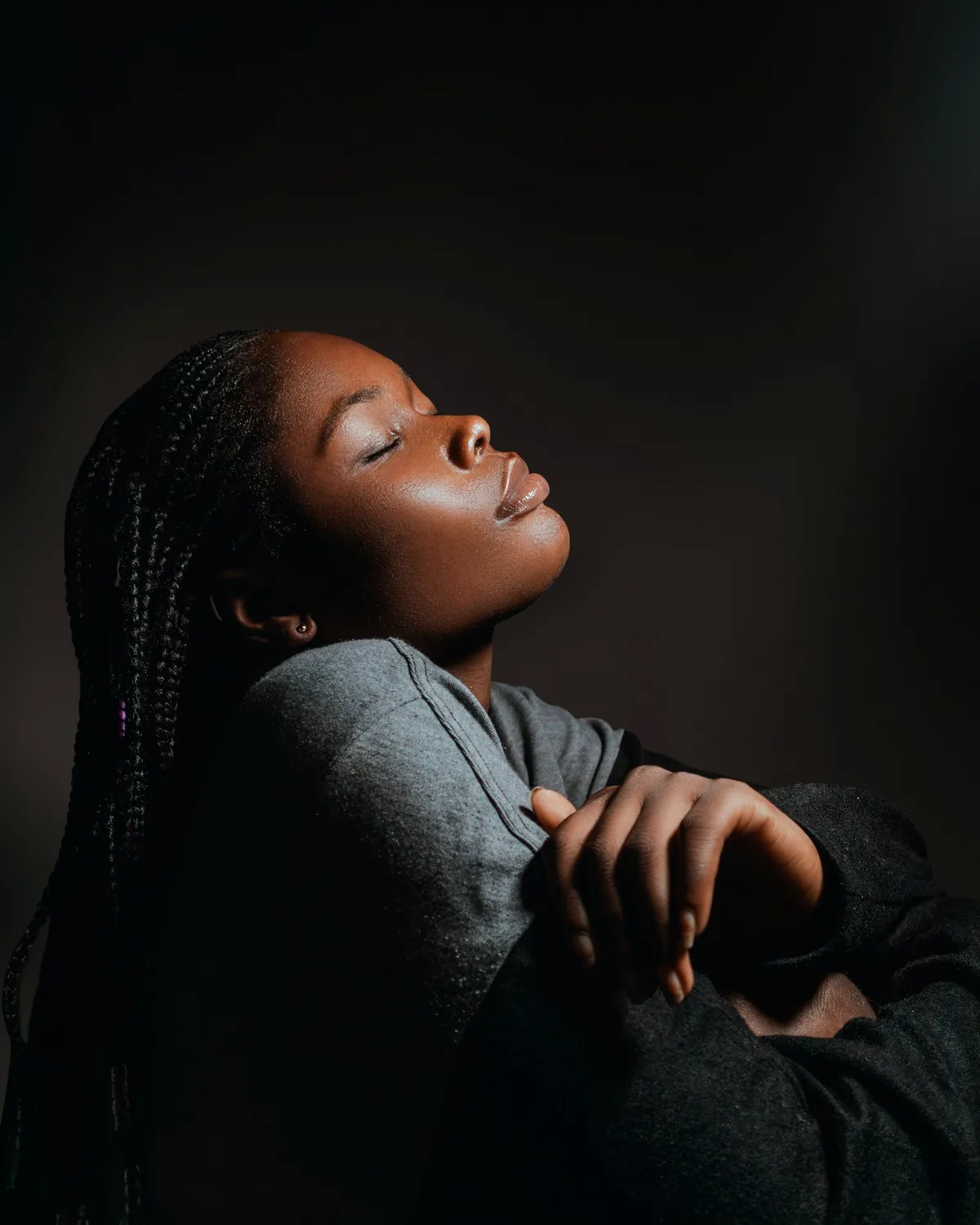A woman with her eyes closed in a quiet, dim room
